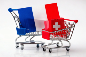 Un caddie avec le drapeau français et un caddie avec le drapeau suisse qui illustre l'impact du taux de change sur votre pouvoir d'achat frontalier suisse