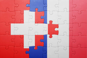 Puzzle aux couleurs des drapeaux suisse et français symbolisant la complexité fiscale du quasi-résident suisse.