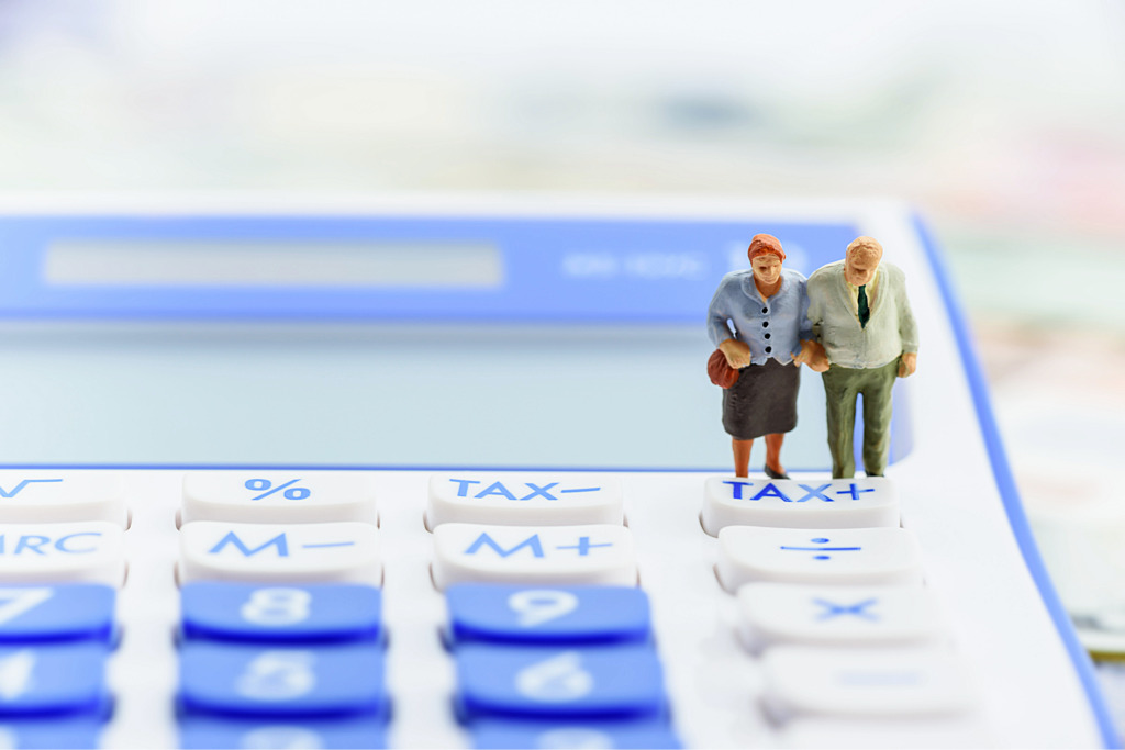 Deux figurines représentant un couple de retraités sur une calculatrice, illustrant le calcul et la déclaration fiscale d’un PER.